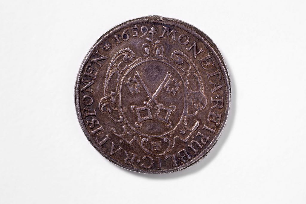 Regensburg, Hieronymus Federer, 1659, 2/3 Taler, Silber, geschlagen, 37 mm, mit Titel Leopold I., Stadtschlüssel in ovaler Barockkartusche, darüber Blume, darunter „HF“ ligiert; am Rand Strichelkreis, Umschrift: „MONETA REIPUBLICA RATISPONEN * 1659“; © Stadt Regensburg /Foto: Stefan Effenhauser