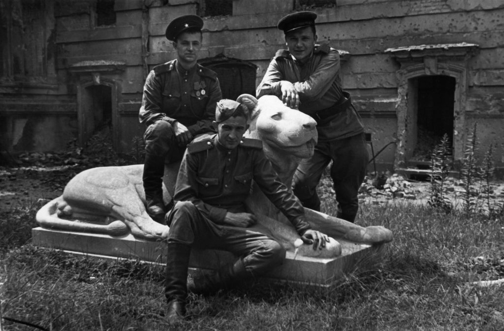 Drei sowjetische Soldaten posieren vor dem „Mosse-Löwen“, Fotografie von Friedrich Seidenstücker, 1945; © bpk / Foto: Friedrich Seidenstücker
