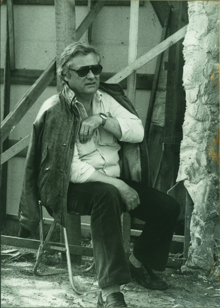 Schwarzweißfoto eines Mannes, sitzend, mit Sonnenbrille