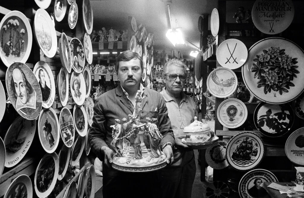 Zwei Männer mit Porzellanobjekten in der Hand