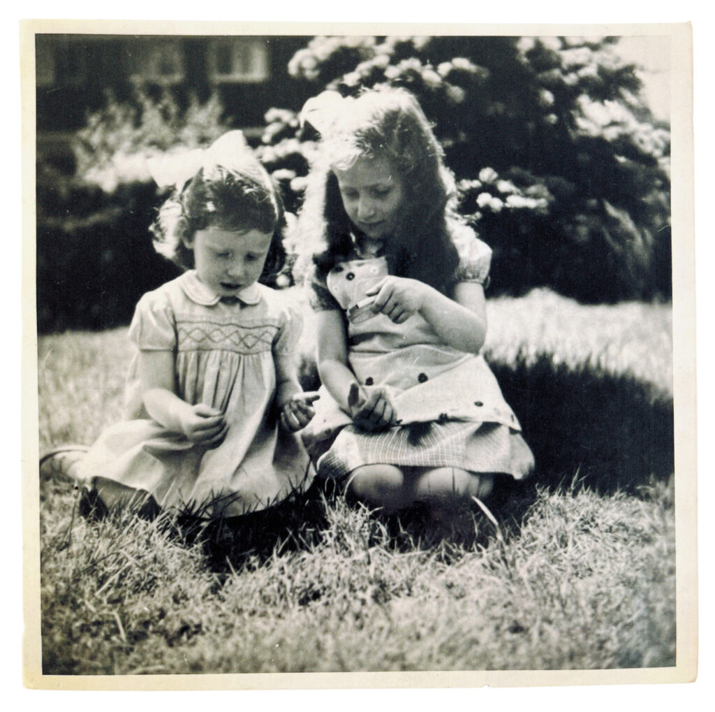 Zwei kleine Mädchen im Gras sitzend