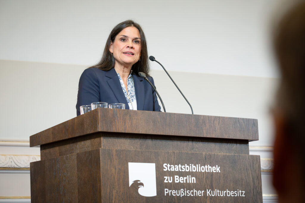 Frau an einem Pult mit Mikrophon